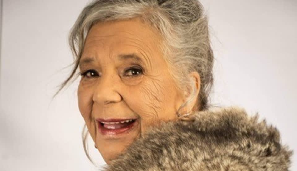 A Wotjobaluk woman in a fur ruff smiles at the camera