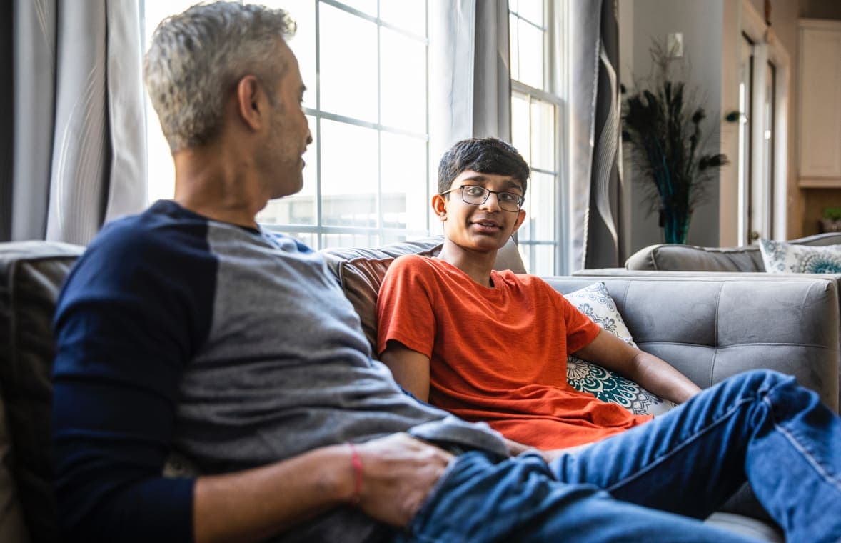 A father and son sitting on a couch