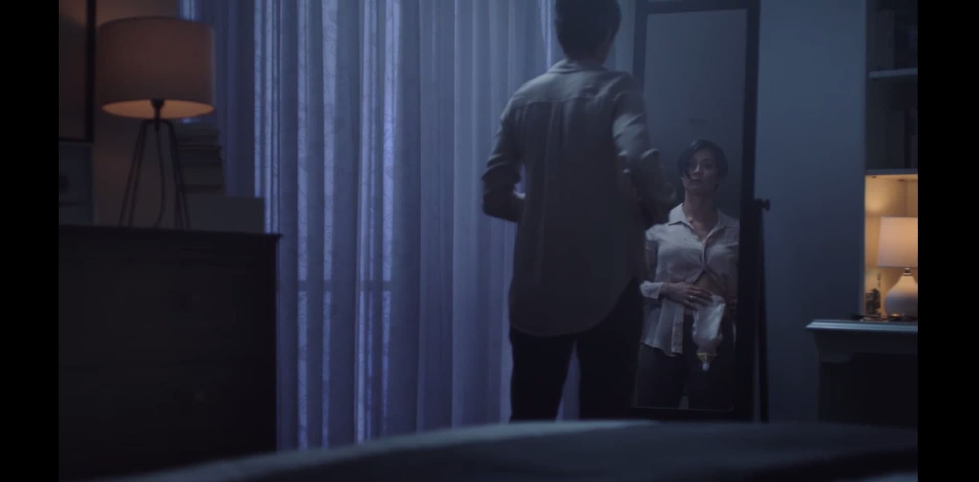 Two people face each other in a dark room