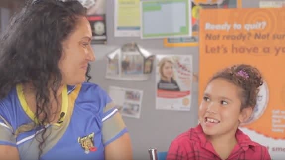 A mother and daughter smile at one another