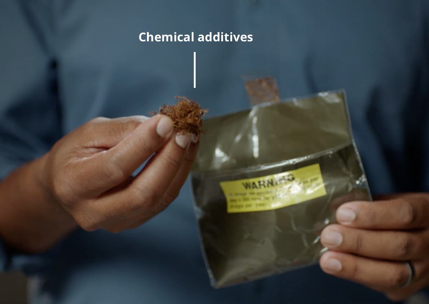 A man holds a bag of pouch tobacco