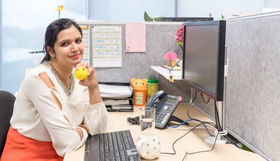 Woman holds stressball smiling at desk photo