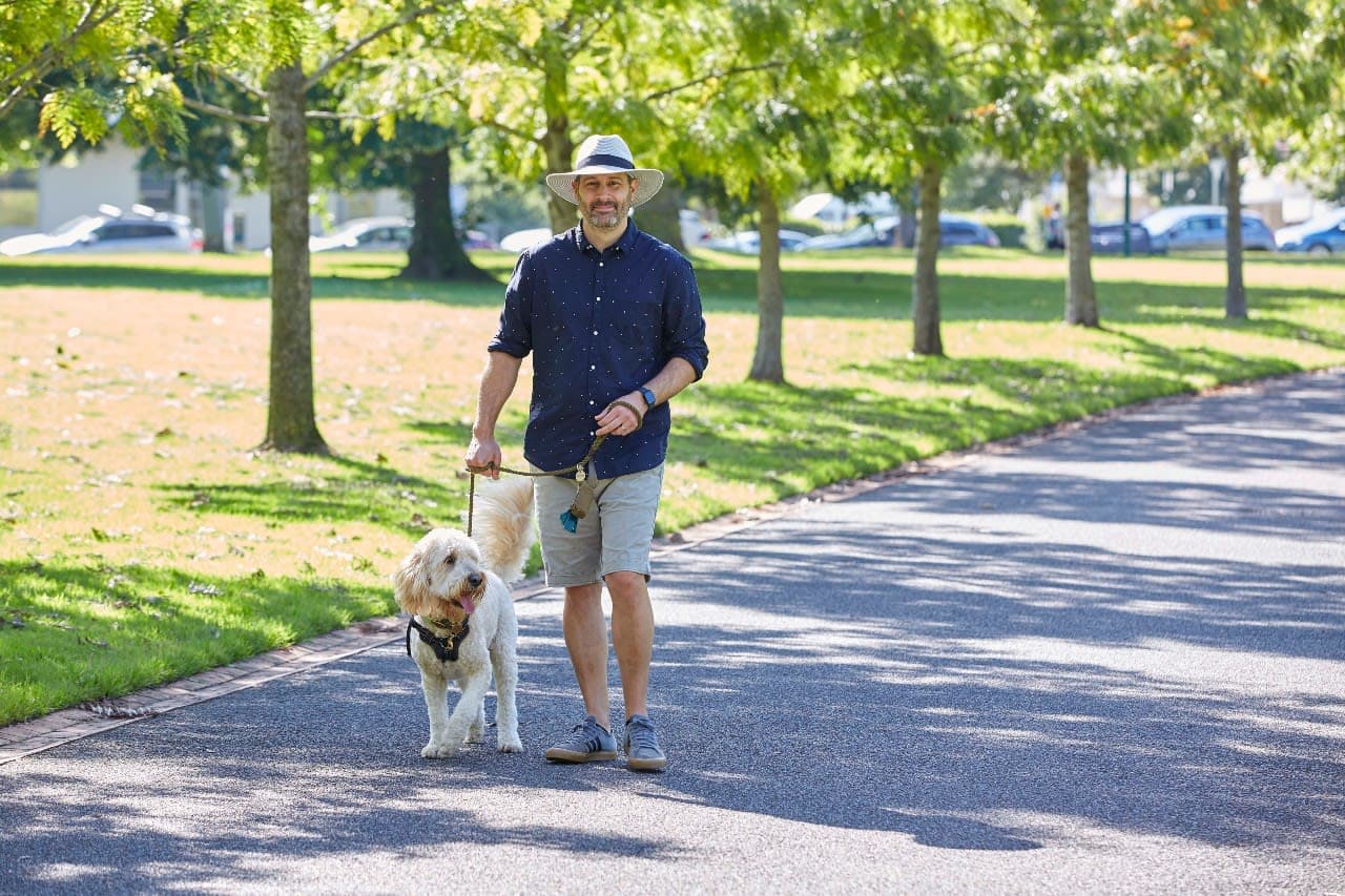 A man walking his dog in a park