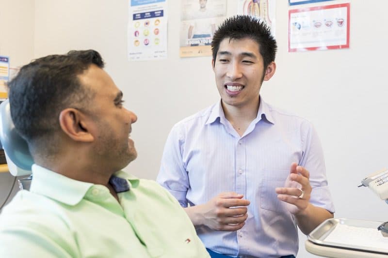 Two men talk in a doctor's clinic