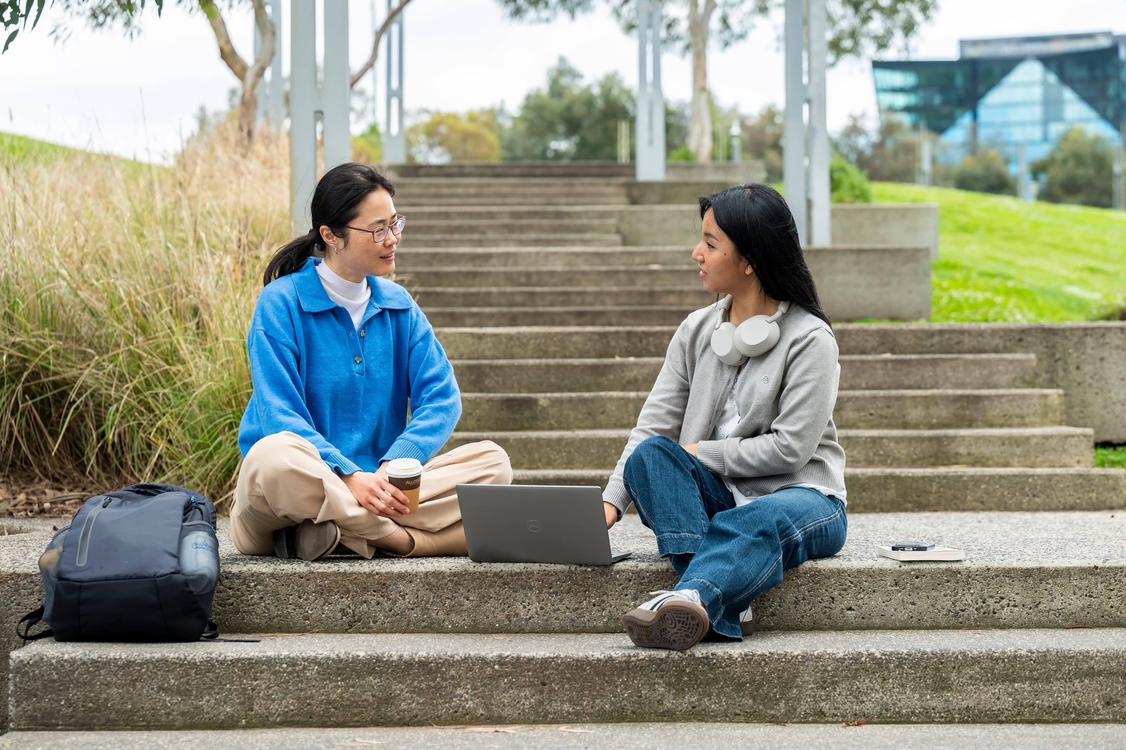 Two women talk in a park.